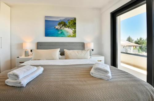 a bedroom with a large bed with towels on it at Villa Mila in Vabriga