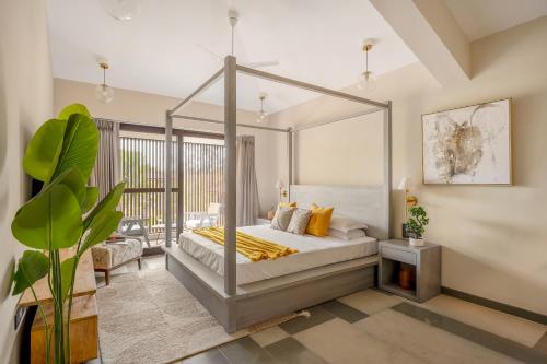 a bedroom with a canopy bed with yellow pillows at Lindsay Manor AkSh Private Pool 4BHK Lift in Arpora