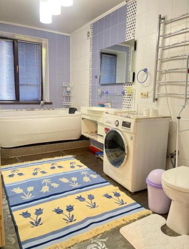 a bathroom with a sink and a washing machine at Apartment in Almaty