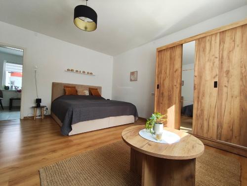 a bedroom with a bed and a wooden table at Fészek Vendégház in Zalaegerszeg