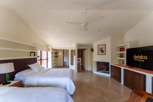 a hotel room with two beds and a flat screen tv at 4000 - Casa San Felipe in Oaxaca City