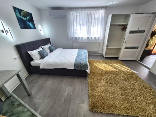 a bedroom with a bed and a table and a rug at Central Residence Targu Mures in Târgu-Mureş