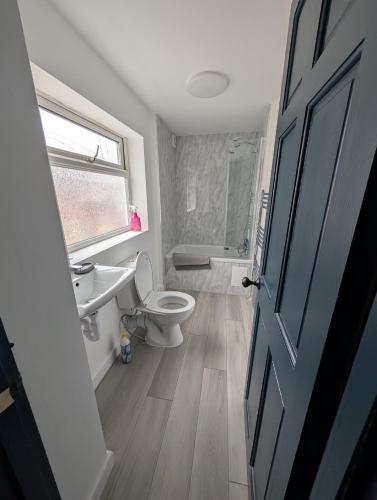 a bathroom with a toilet and a sink and a shower at Entire Home in Denton in Denton