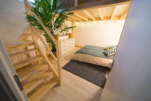 a bedroom with a bed and a staircase in a room at AppartUnique - Chez Helder - Standing, Calme & Design in Vichy