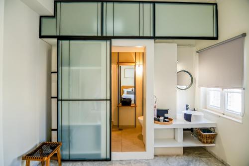 a room with a glass door leading to a bathroom at OIKO MINI SUITES in Ermoupoli
