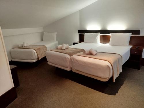 a hotel room with two beds with white pillows at Hotel BESTPRICE Toledo in Toledo