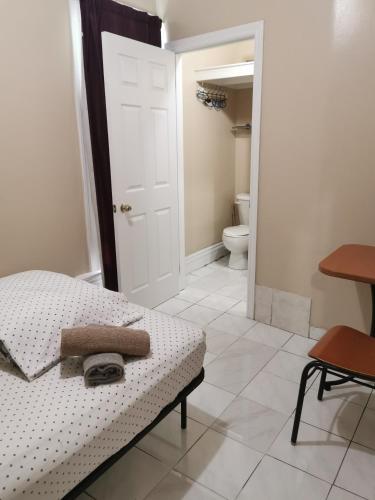 a bedroom with a bed and a bathroom with a toilet at Toronto Travellers Home in Toronto