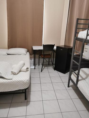 a room with two beds and a table and chairs at Toronto Travellers Home in Toronto