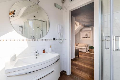 a bathroom with a white sink and a mirror at Alassio White Loft in Alassio