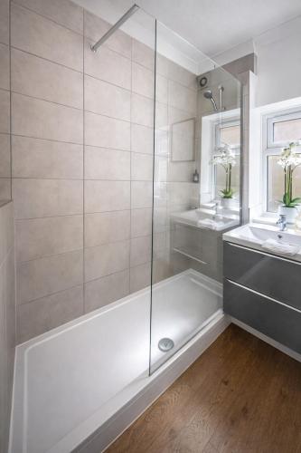 a white bathroom with a shower and a sink at Central Cambridge Fig Tree house in Cambridge
