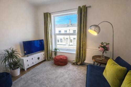 a living room with a tv and a window at Central Cambridge Fig Tree house in Cambridge