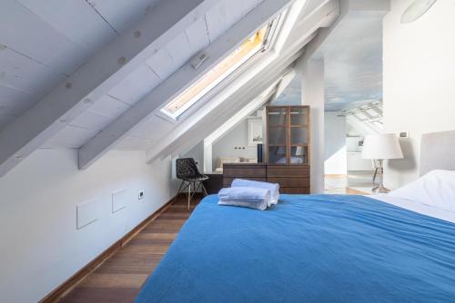 an attic bedroom with a blue bed and a desk at Alassio White Loft in Alassio