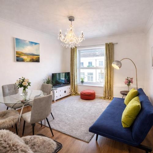 a living room with a blue couch and a table at Central Cambridge Fig Tree house in Cambridge