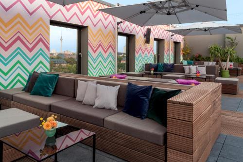 a lobby with couches and tables and a colorful wall at Hotel AMANO Grand Central in Berlin