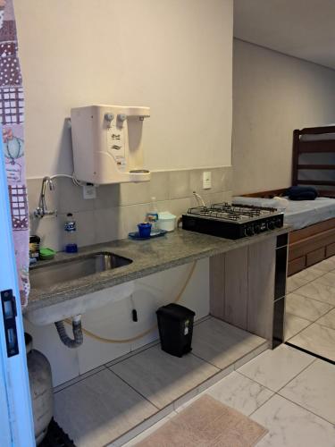 a kitchen counter with a sink and a stove at Kitnet 4 Vila Lunardi in Campinas