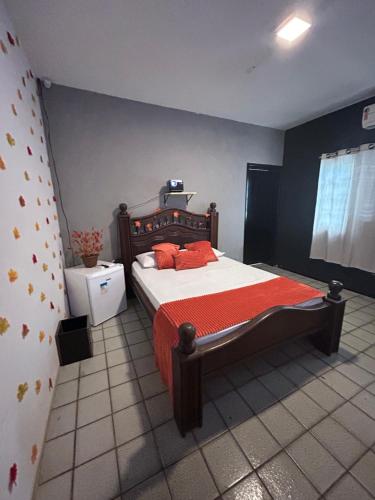 a bedroom with a bed with red pillows on it at Green Suíte Comfort in Garanhuns