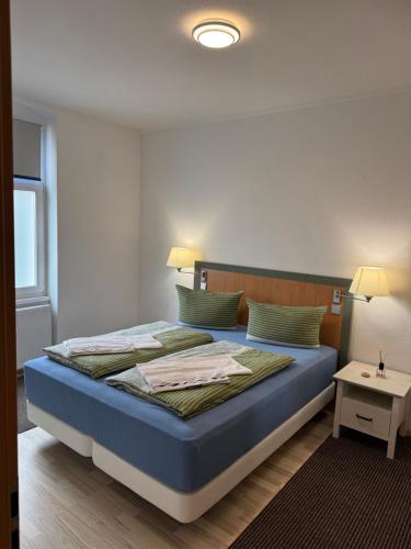 a bedroom with a bed with a blue comforter at Ferienwohnung Florion 4 in Bernburg