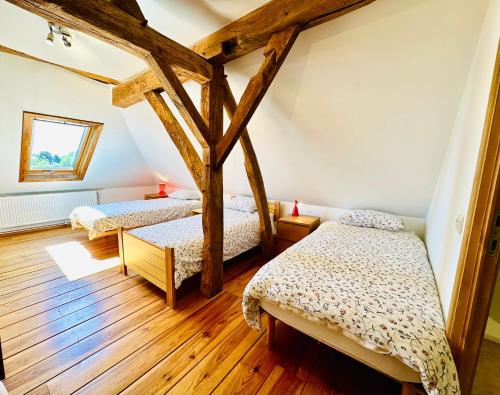 two beds in a room with wooden floors at Moulin de Meeffe in Wasseiges