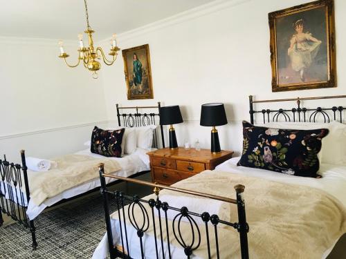 a bedroom with two beds and a chandelier at Klaarstroom Hotel in Klaarstroom