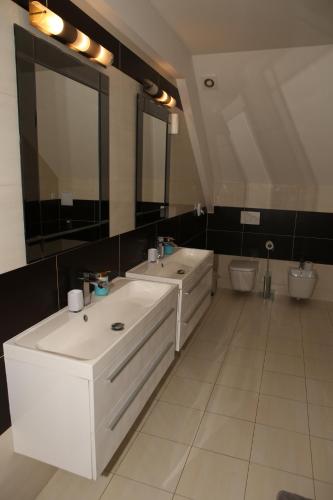 a bathroom with two sinks and a large mirror at Apartment Kotva in Bratislava