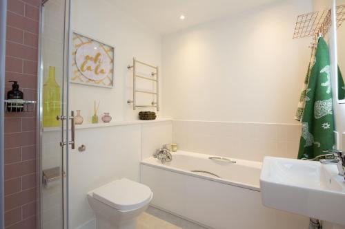 a bathroom with a tub and a toilet and a sink at Oxfordshire Living - The Alice Apartment - Oxford in Oxford