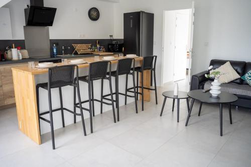 a kitchen with a bar with black chairs and a counter at Villa Champan in La Ciotat