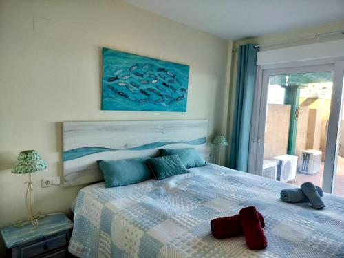 a bedroom with a bed with a red object on it at Anitas Seaview Paradise in La Línea de la Concepción