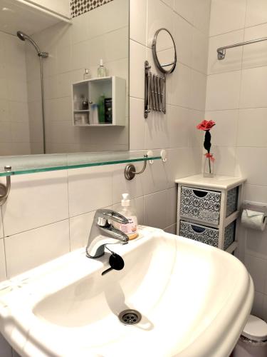 a white bathroom with a sink and a mirror at Anitas Seaview Paradise in La Línea de la Concepción