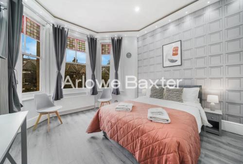 a bedroom with a large bed and two chairs at Hackney Deluxe Rooms in London