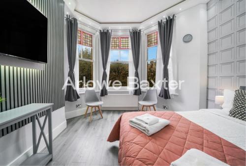 a bedroom with a bed and a desk at Hackney Deluxe Rooms in London