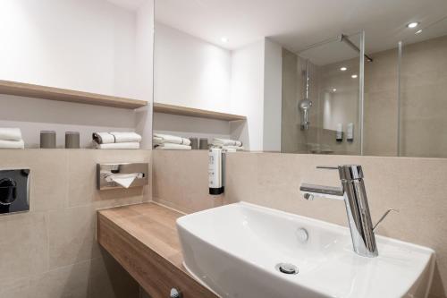 a bathroom with a sink and a mirror at HARBR Hotel Ludwigsburg, a member of Radisson Individuals in Ludwigsburg