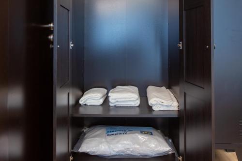 a closet with two white towels on a shelf at Social Lodge Hollywood Studios in Funchal