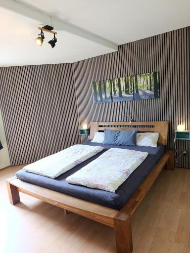 a bedroom with a large bed with blue sheets at FeWO Koeppe in Kopp