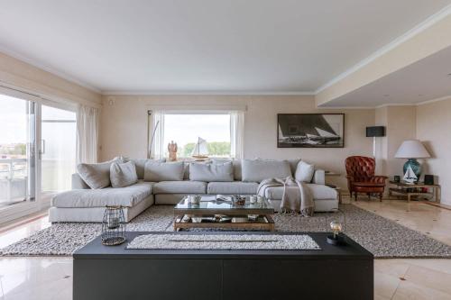 a living room with a couch and a table at Casiola - Apartment with lake view & common indoor pool in Knokke-Heist