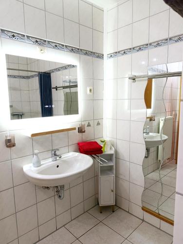 a bathroom with a sink and a mirror and a shower at FeWO Koeppe in Kopp