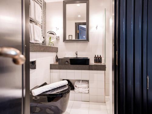 a bathroom with a toilet and a sink and a mirror at Hotel Kungsträdgården in Stockholm