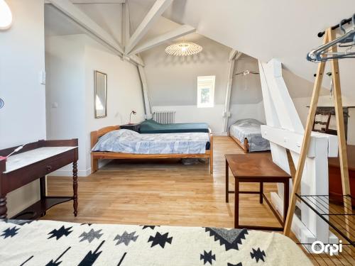 a bedroom with two beds and a piano at REF 495 Quéven type 7 manor house in Quéven
