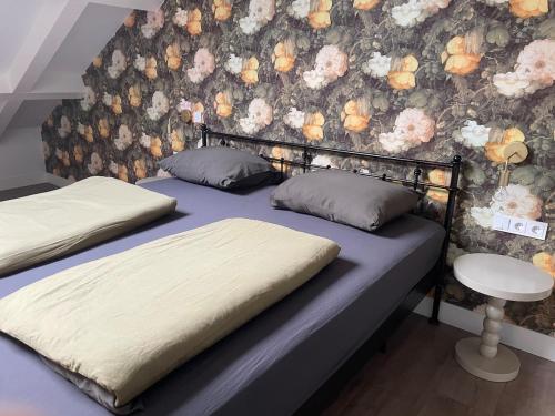 two twin beds in a bedroom with a floral wallpaper at 't Meuleveld in Harskamp