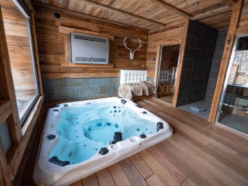 a jacuzzi tub in a cabin with a tv at Chalet Caribou in Isola