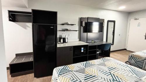 a small kitchen with a black refrigerator in a room at Studio 6 Suites Lexington, Kentucky in Lexington