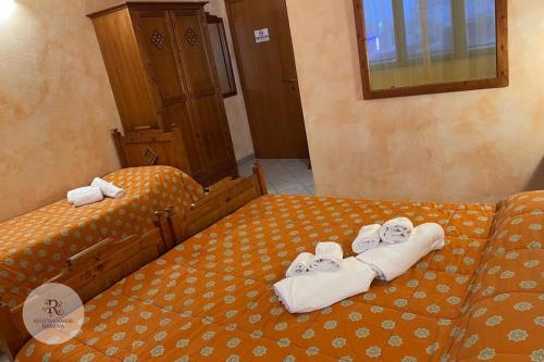 two twin beds with towels on top of them at Affittacamere Ramina in San Giuseppe