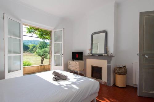 a bedroom with a bed with a fireplace and a mirror at Maison avec jardin proche plages & village in Gassin