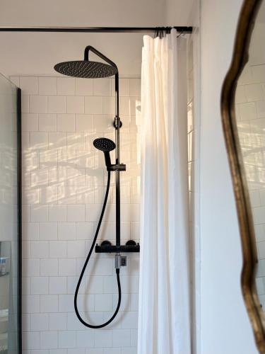 a shower in a bathroom with a shower curtain at Maison LE 2 in Solre-le-Château