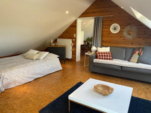 a bedroom with a bed and a couch and a table at Studio à la campagne in Jalhay