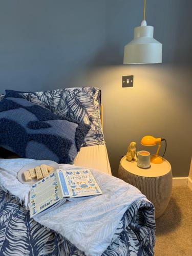 a bedroom with a bed with a book on it at The Hutch Devon in Longdown