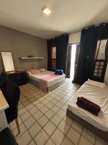 a bedroom with two beds and a tiled floor at Grey Flat Comfort in Garanhuns
