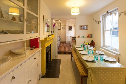 a kitchen with a long table with plates on it at Sunshine Villa Broadstairs sleeps 8 close to beach in Broadstairs