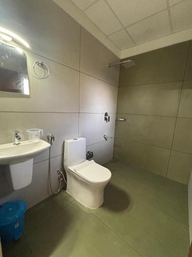 a bathroom with a toilet and a sink at Times Villa in Anachal