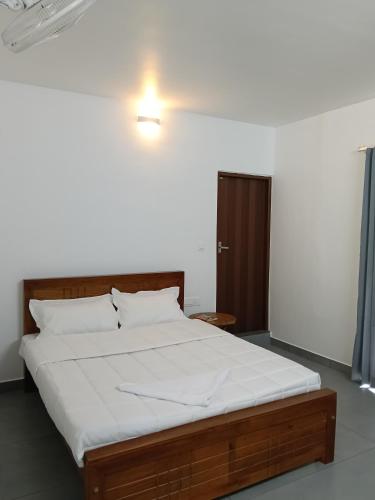 a bedroom with a large bed with white sheets at Times Villa in Anachal