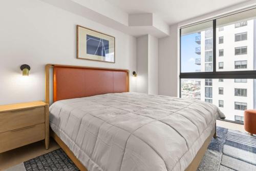 a bedroom with a large bed and a large window at Downtown Luxury Condo withPool & Skyline Views in Miami